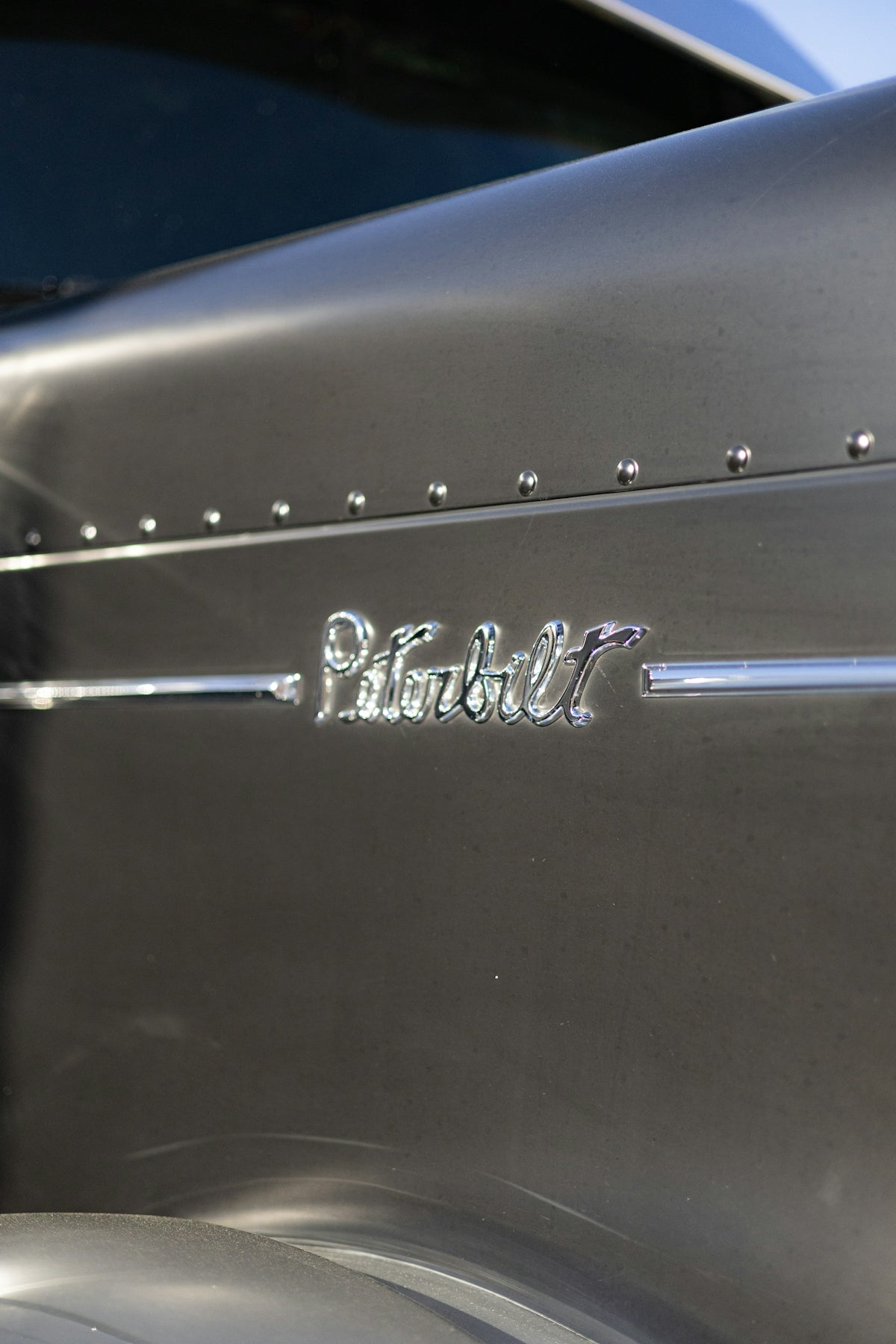 Close-up of a shiny peterbilt truck emblem.